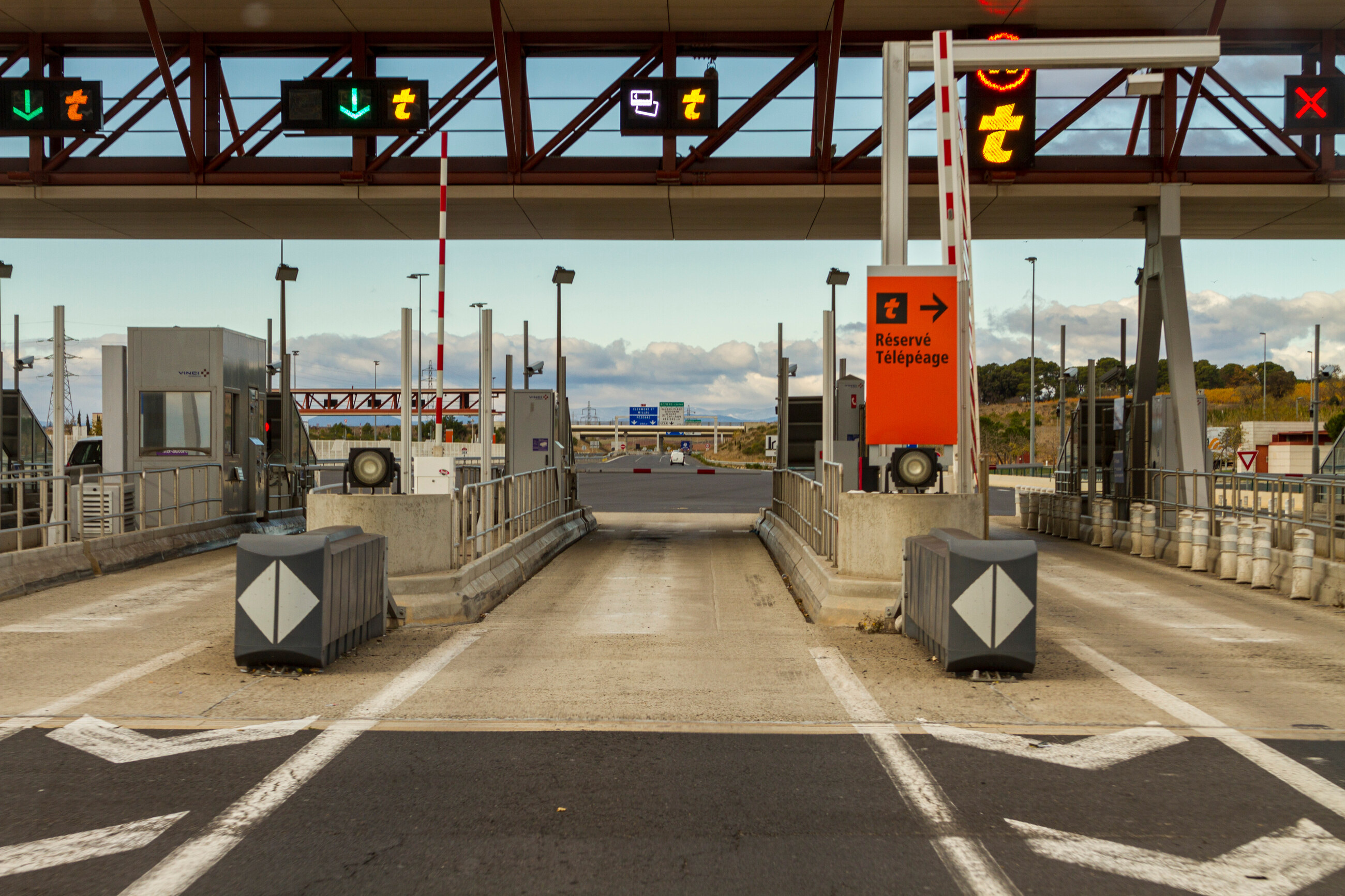 Voies de péage autoroutier avec signalisation lumineuse au-dessus des files